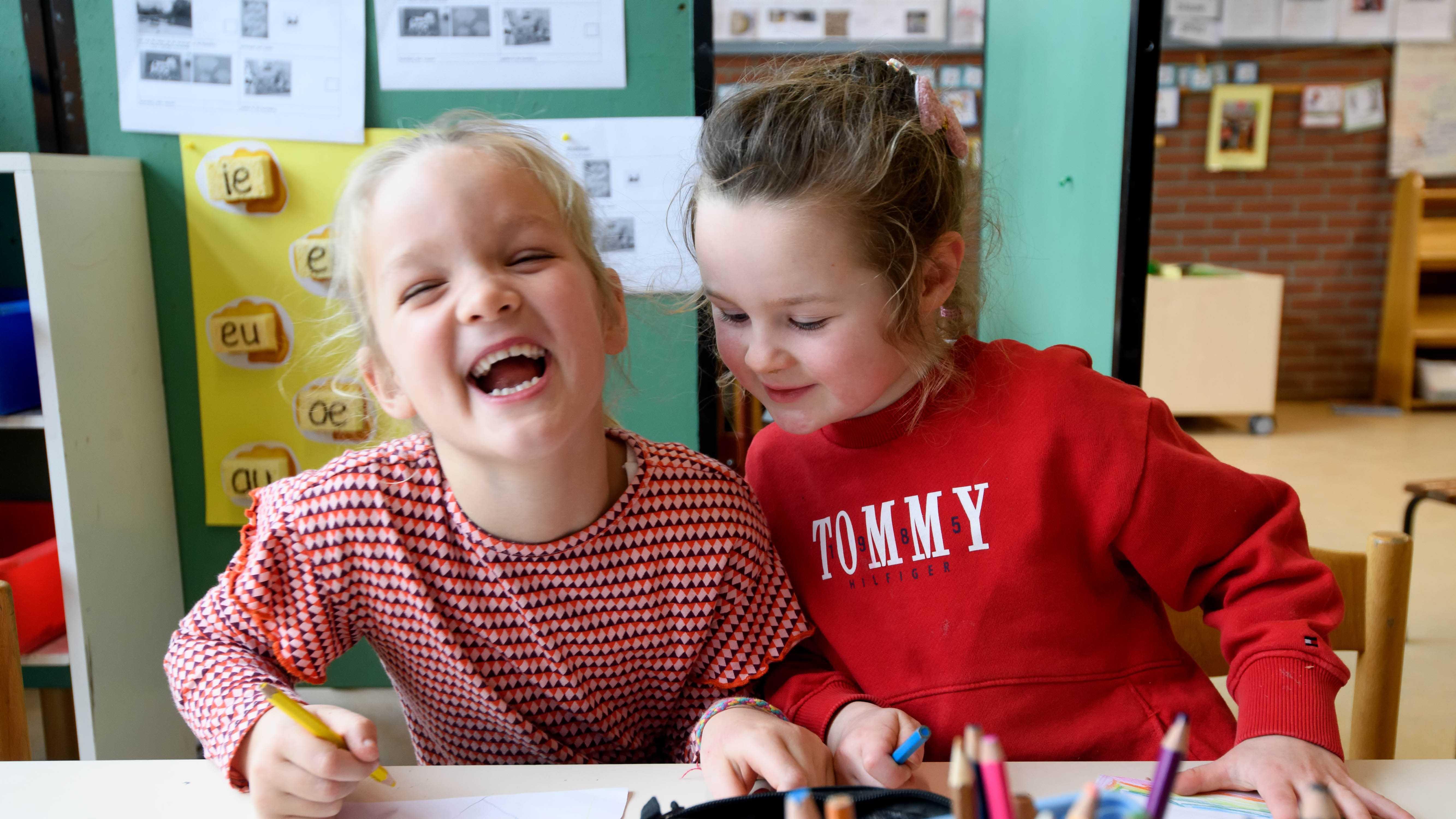 Twee vrolijke meisjes zijn samen aan het tekenen in de klas van Basisschool St Wulfram in Hoogwoud. Twee vrolijke meisjes zijn samen aan het tekenen in de klas van Basisschool St Wulfram in Hoogwoud.