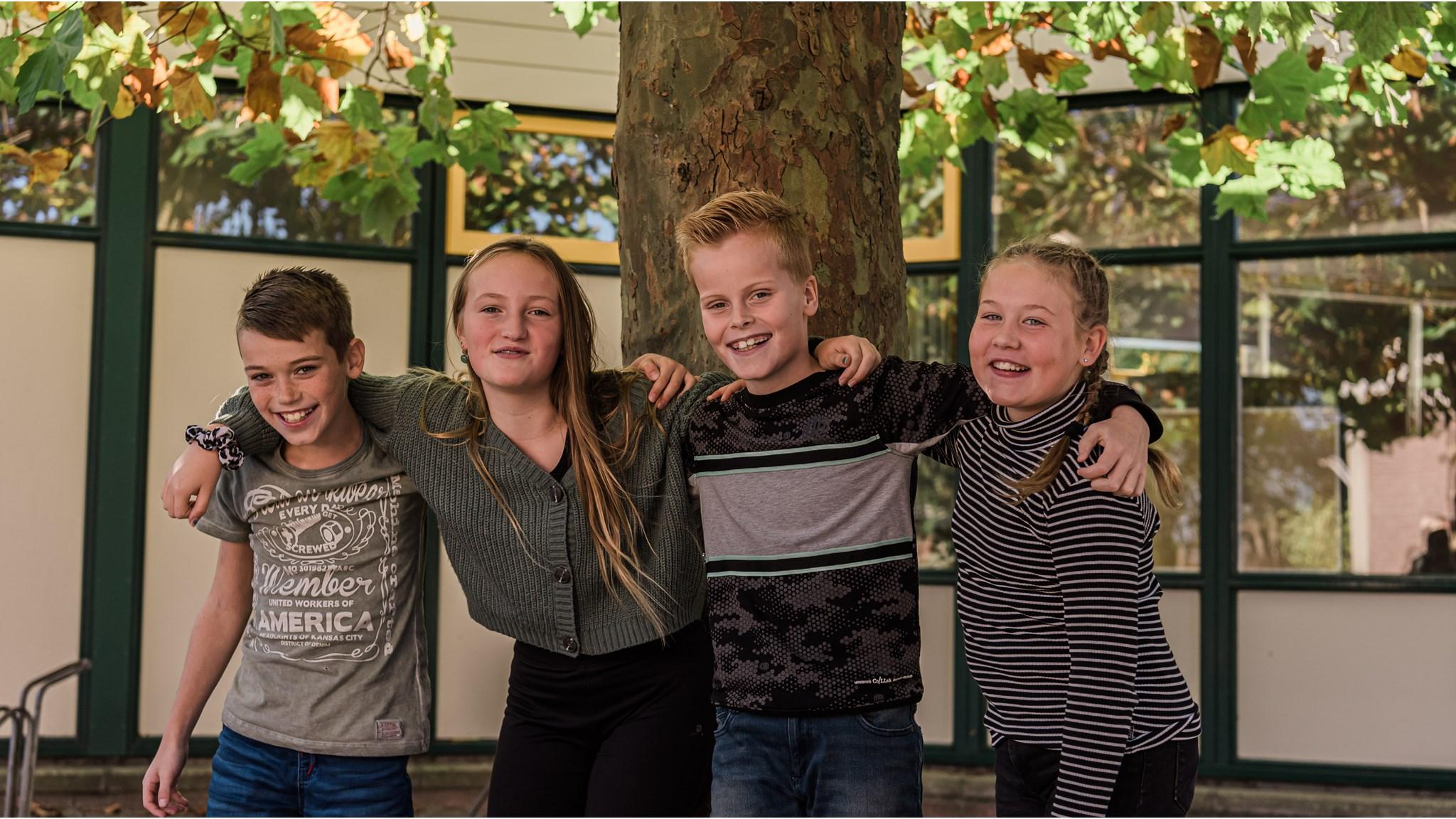 Vier blije leerlingen van De Rietlanden in Marken samen op het schoolplein.