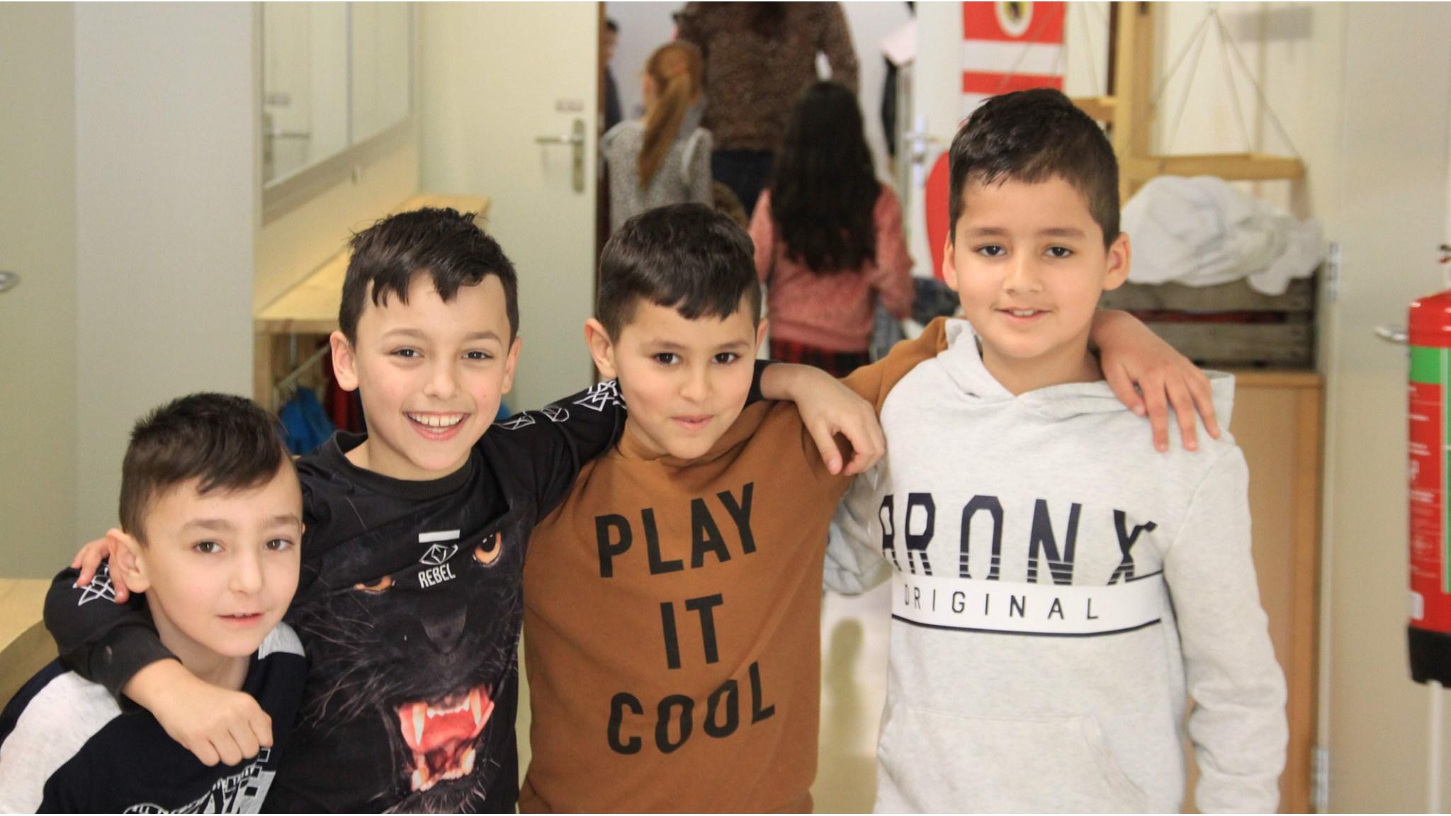 Vier kinderen poseren lachend samen in de gang van IKC Eestroom in Leeuwarden. Vier kinderen poseren lachend samen in de gang van IKC Eestroom in Leeuwarden.