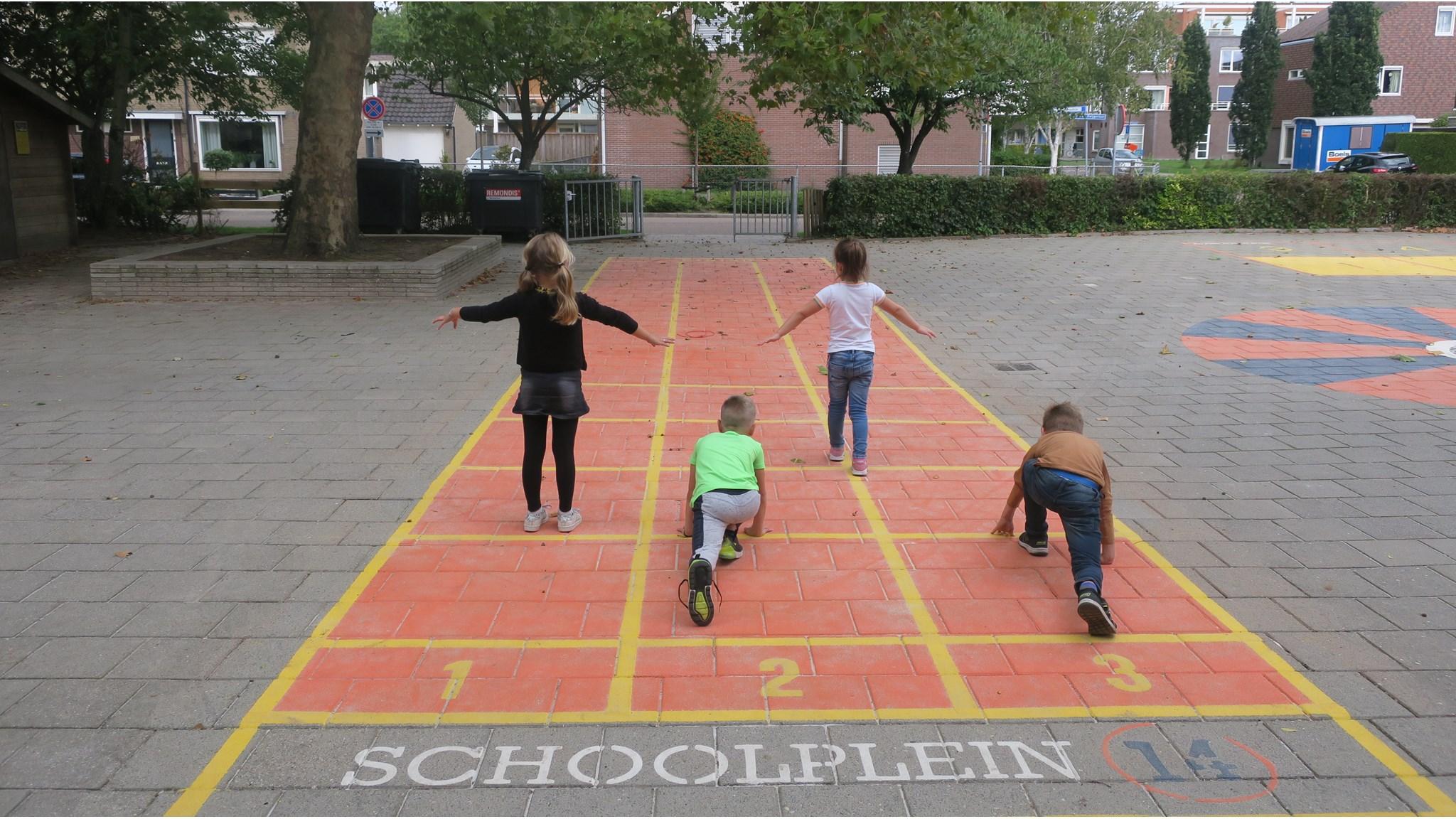 Vier kinderen spelen op het schoolplein van Drostenburg in Amsterdam. Vier kinderen spelen op het schoolplein van Drostenburg in Amsterdam.