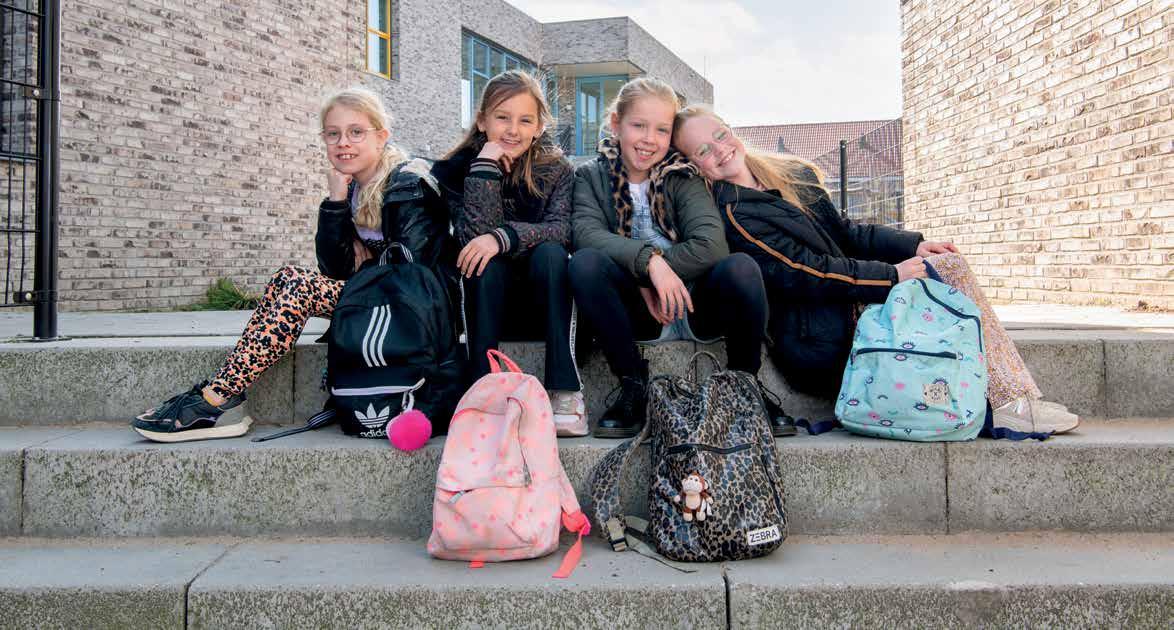 Vier leerlingen van Kindcentrum De Spreng in Hoevelaken poseren vrolijk op de trappen van het schoolplein. Vier leerlingen van Kindcentrum De Spreng in Hoevelaken poseren vrolijk op de trappen van het schoolplein.