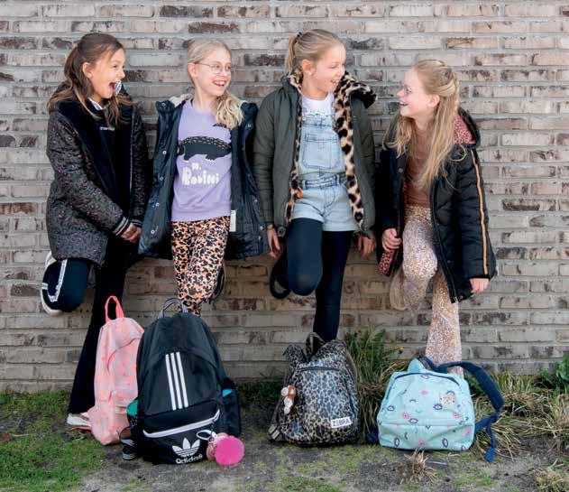 Vier meisjes met schooltassen poseren vrolijk op het schoolplein van Kindcentrum De Spreng in Hoevelaken. Vier meisjes met schooltassen poseren vrolijk op het schoolplein van Kindcentrum De Spreng in Hoevelaken.