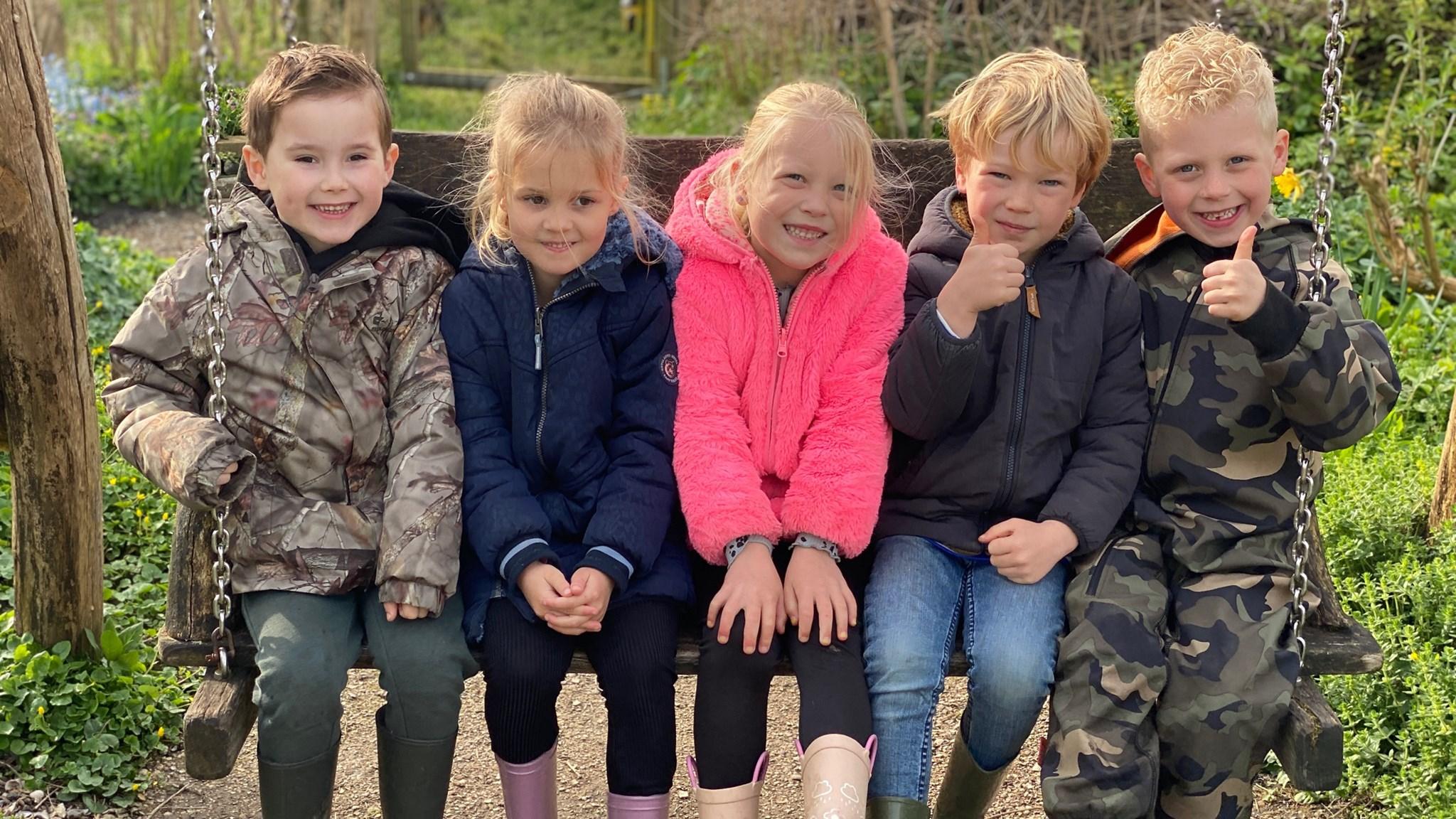 Vijf blije kinderen op de schommels van het schoolplein van de Katholieke Basisschool De Bangert in Andijk. Vijf blije kinderen op de schommels van het schoolplein van de Katholieke Basisschool De Bangert in Andijk.