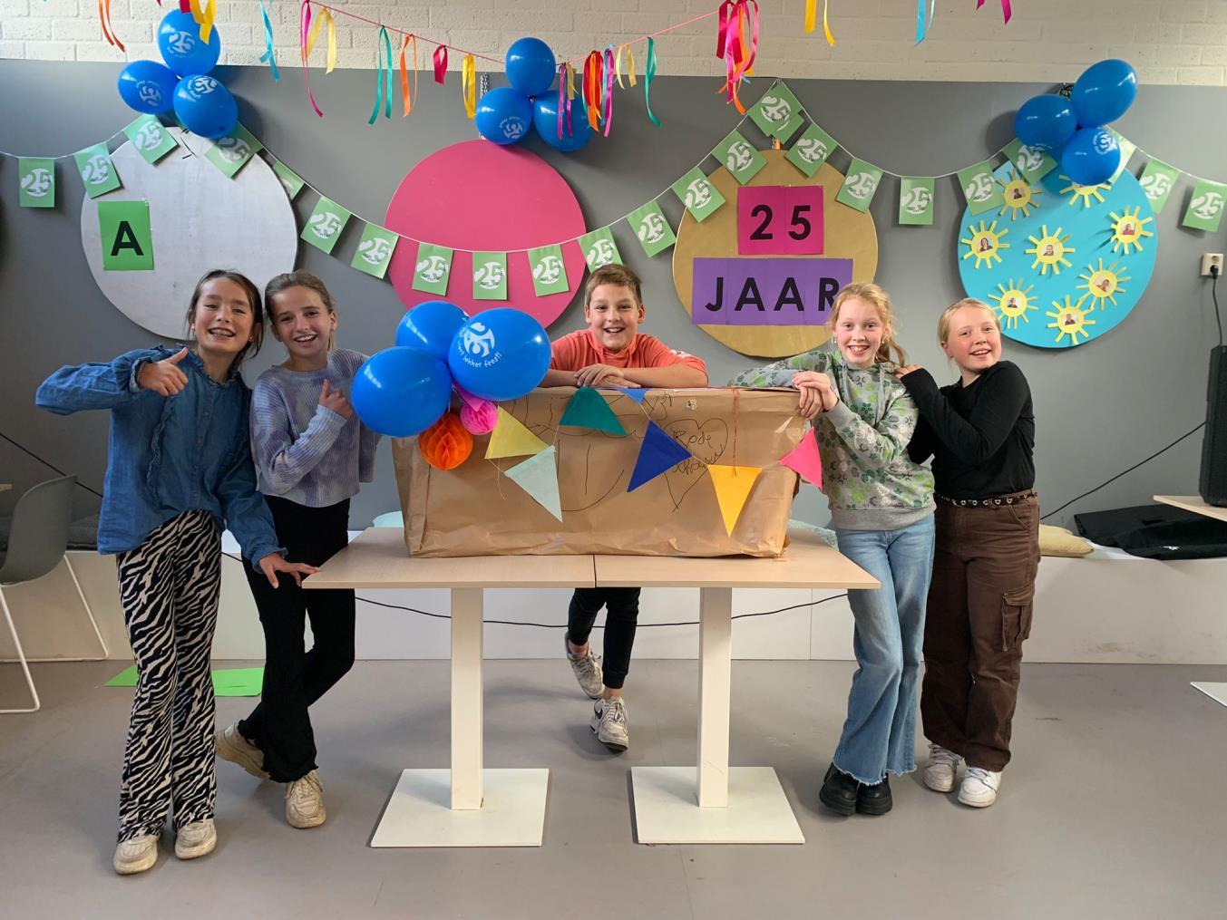 Vijf leerlingen van Basisschool De Rode Schouw in Halsteren vieren samen een speciale gelegenheid met versiering en ballonnen. Vijf leerlingen van Basisschool De Rode Schouw in Halsteren vieren samen een speciale gelegenheid met versiering en ballonnen.