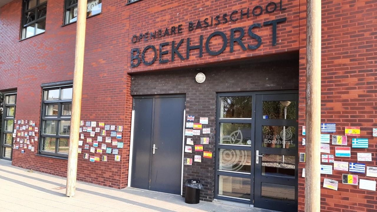 Voorkant van Openbare Basisschool Boekhorst in Oosterwolde (Fryslân) met kleurrijke vlaggen aan de muur. Voorkant van Openbare Basisschool Boekhorst in Oosterwolde (Fryslân) met kleurrijke vlaggen aan de muur.