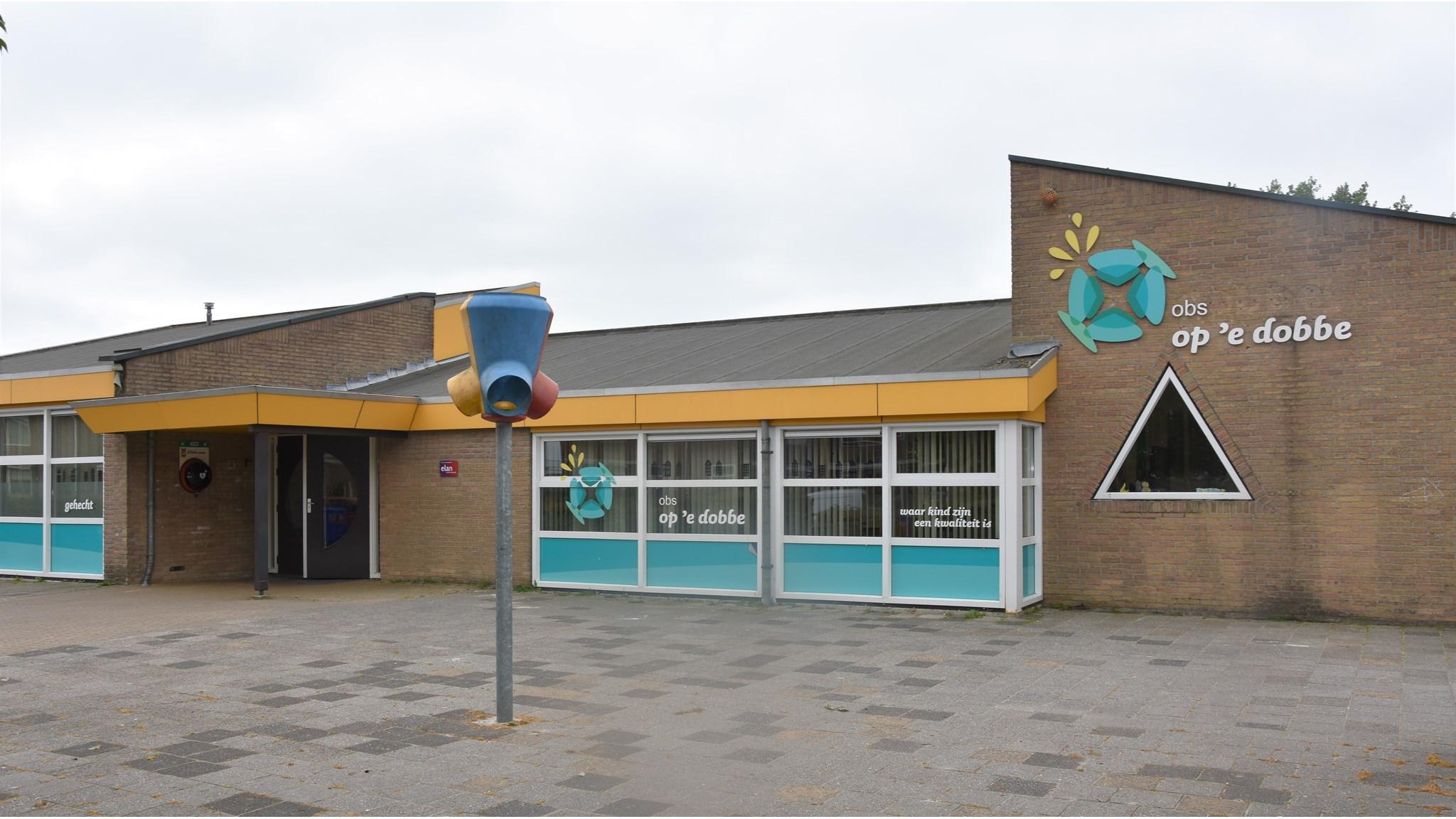 Voorzijde van o.b.s. 'Op 'e Dobbe' in Hallum met een kleurrijk speeltoestel en een moderne uitstraling. Voorzijde van o.b.s. 'Op 'e Dobbe' in Hallum met een kleurrijk speeltoestel en een moderne uitstraling.