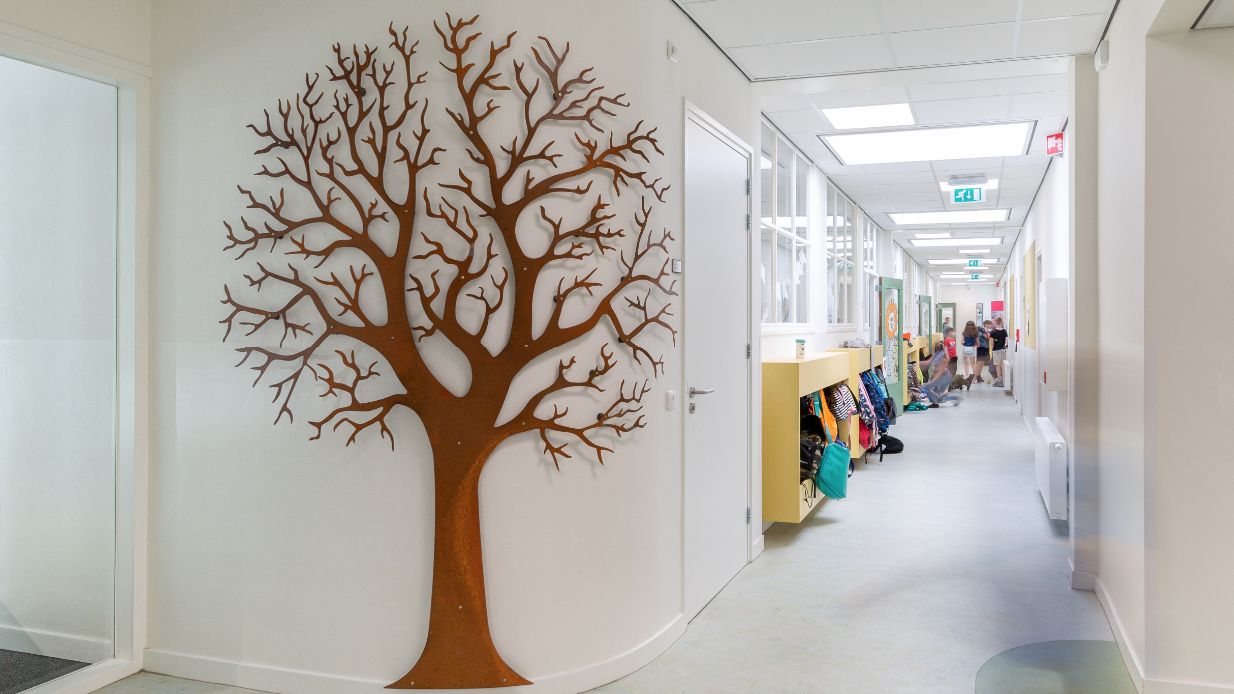 Zaal in basisschool Windkracht 10 in Emmeloord met een decoratieve boom op de muur. Zaal in basisschool Windkracht 10 in Emmeloord met een decoratieve boom op de muur.