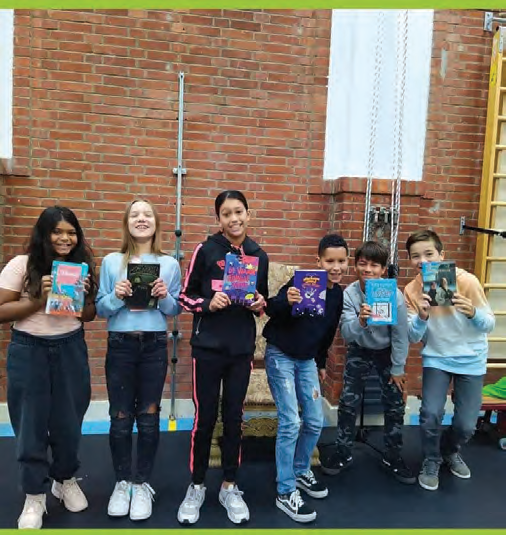 Zes leerlingen van De Vlierboom in Den Haag houden blije boeken omhoog in de gymzaal. Zes leerlingen van De Vlierboom in Den Haag houden blije boeken omhoog in de gymzaal.